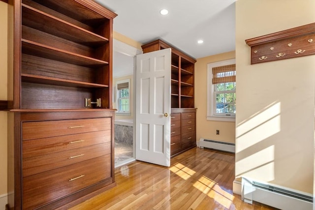 walk in closet featuring baseboard heating and light wood-style flooring