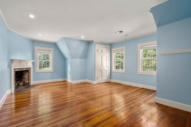 unfurnished living room with hardwood / wood-style flooring, a fireplace, and ornamental molding