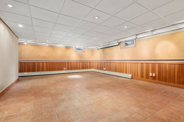 spare room featuring a paneled ceiling and wooden walls