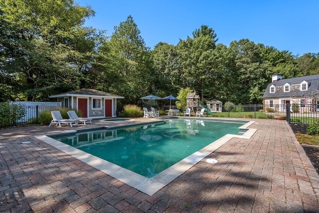 view of swimming pool with an outdoor structure and a patio