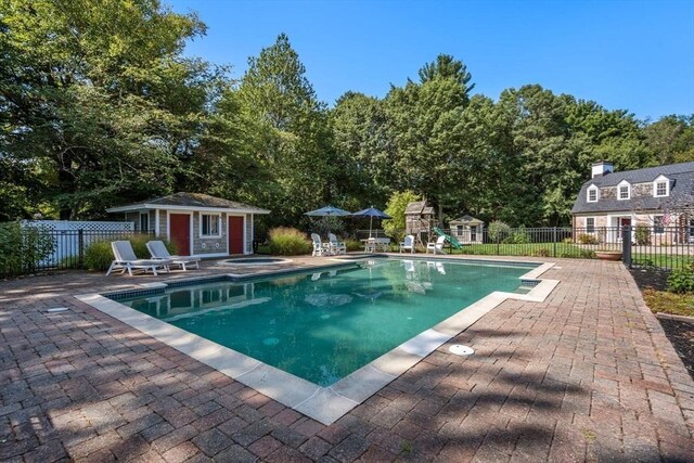 view of pool featuring a fenced in pool, a patio, an outbuilding, fence, and an exterior structure