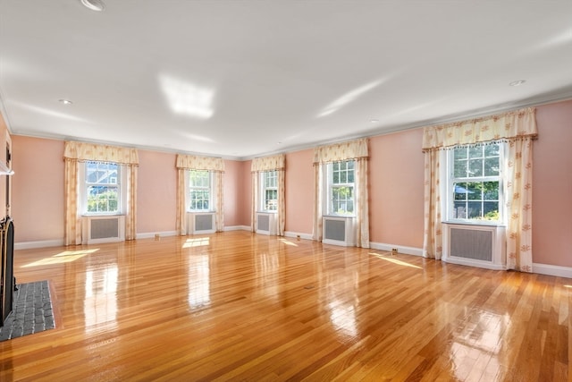 unfurnished living room with light hardwood / wood-style floors and ornamental molding