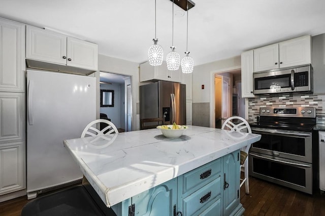 kitchen featuring white cabinets, appliances with stainless steel finishes, a center island, light stone counters, and blue cabinets