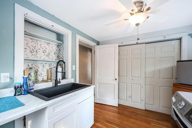 kitchen featuring sink, ceiling fan, white cabinetry, and light hardwood / wood-style floors