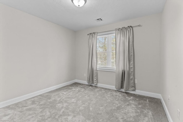 carpeted empty room featuring baseboards and visible vents