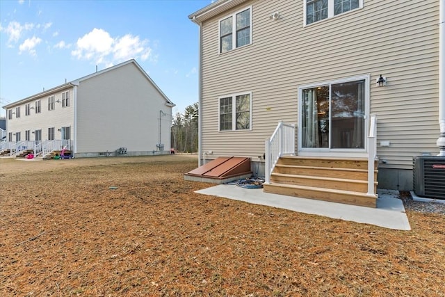 back of property with cooling unit, a yard, and entry steps