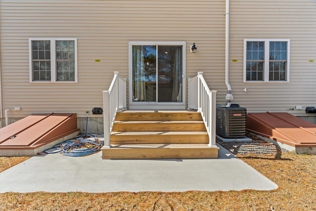 view of exterior entry featuring central air condition unit