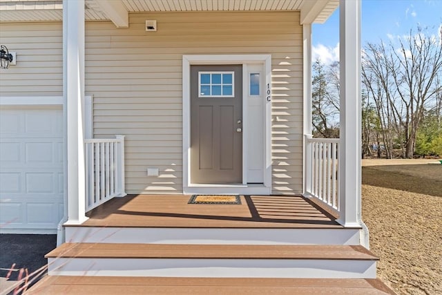 entrance to property featuring a garage and covered porch