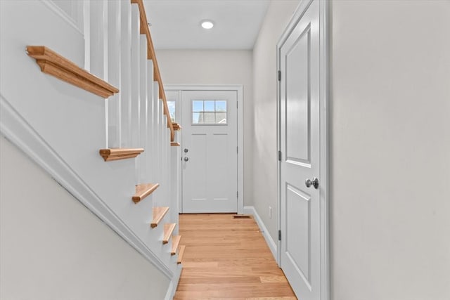 doorway to outside with stairs, light wood-style floors, and baseboards