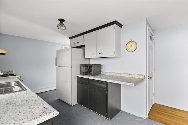 kitchen featuring white cabinets and white refrigerator