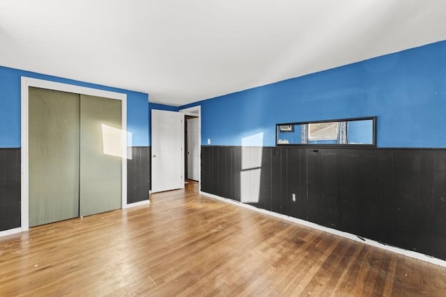 unfurnished bedroom featuring a closet and hardwood / wood-style floors