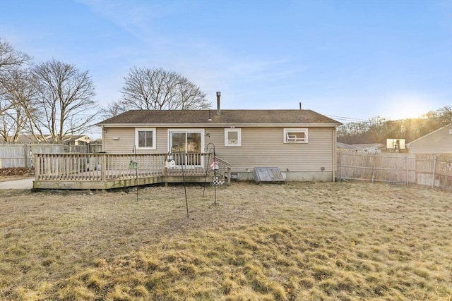 rear view of house featuring a yard and a wooden deck