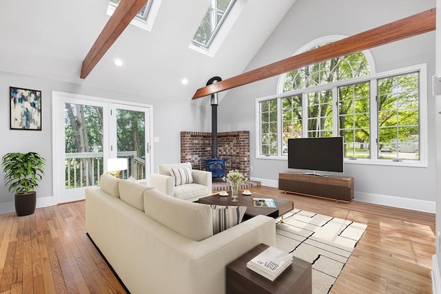 2 Pauls Way, Newbury, MA 01951 - living area featuring a wood stove, baseboards, wood finished floors, a skylight, and high vaulted ceiling