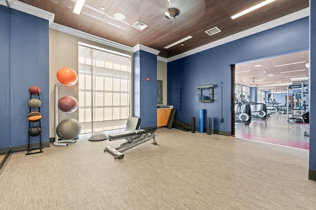exercise room with visible vents, baseboards, crown molding, and carpet floors