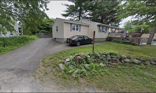 view of front of house with a wooden deck and a front lawn