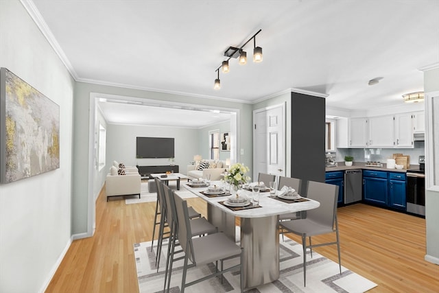 dining room featuring light wood-type flooring and crown molding