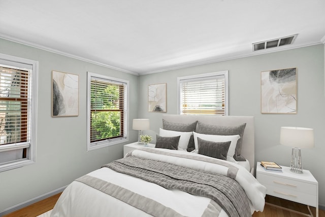 bedroom featuring wood-type flooring and ornamental molding