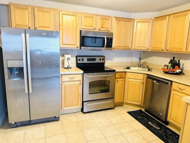 kitchen featuring a sink, stainless steel appliances, a textured ceiling, and light countertops