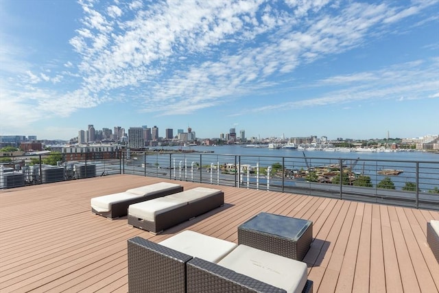 wooden terrace featuring a water view and a city view