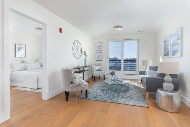 living area with baseboards and wood finished floors