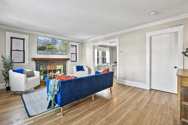 living room with a brick fireplace, ornamental molding, and light hardwood / wood-style floors