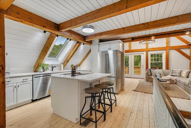 66 S W Dr, Dennis, MA 02638 - kitchen featuring stainless steel appliances, a skylight, light wood-type flooring, open floor plan, and a breakfast bar area