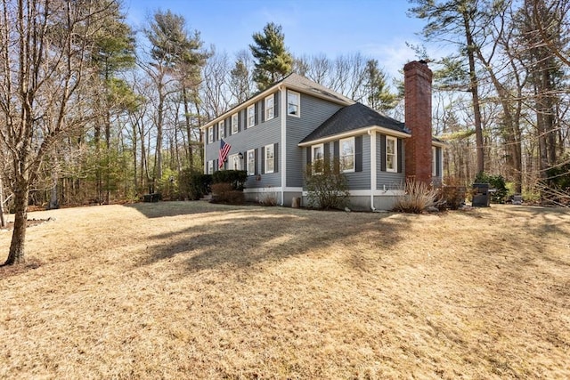 view of property exterior with roof with shingles and a chimney