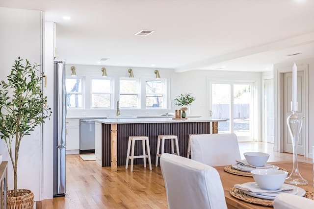 dining space featuring sink and light wood-type flooring