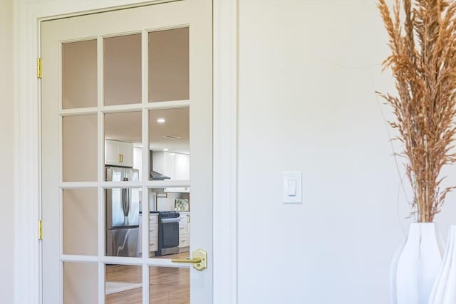 details featuring stainless steel appliances and wall chimney exhaust hood