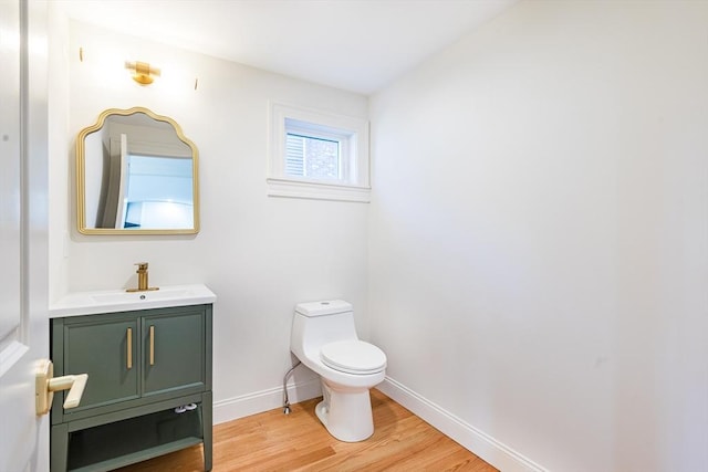 bathroom featuring vanity, wood-type flooring, and toilet