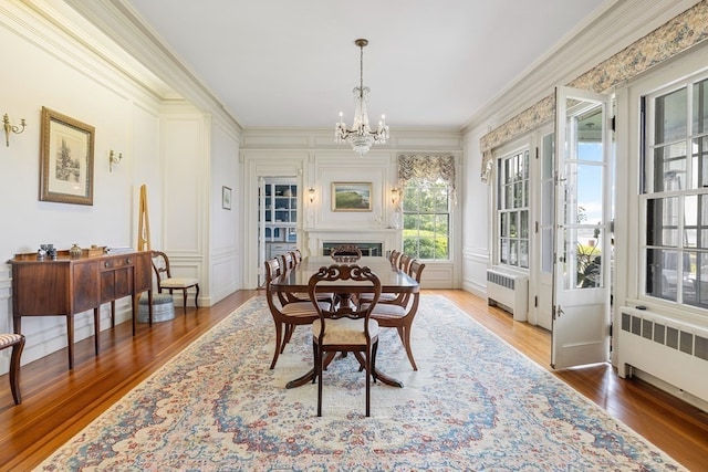 interior space with dark hardwood / wood-style flooring, a notable chandelier, ornamental molding, and radiator