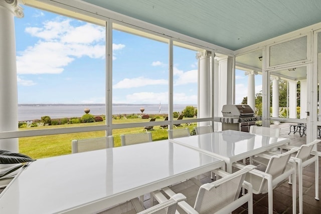 sunroom / solarium featuring a water view and plenty of natural light