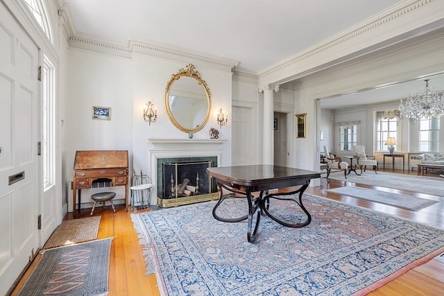 interior space featuring a chandelier, light wood-type flooring, and crown molding