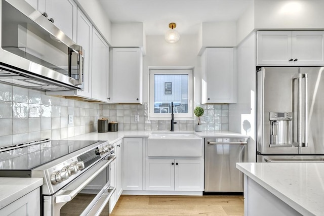 148 Myrtle Unit 1, Melrose, MA 02176 - kitchen with decorative backsplash, white cabinetry, stainless steel appliances, and a sink