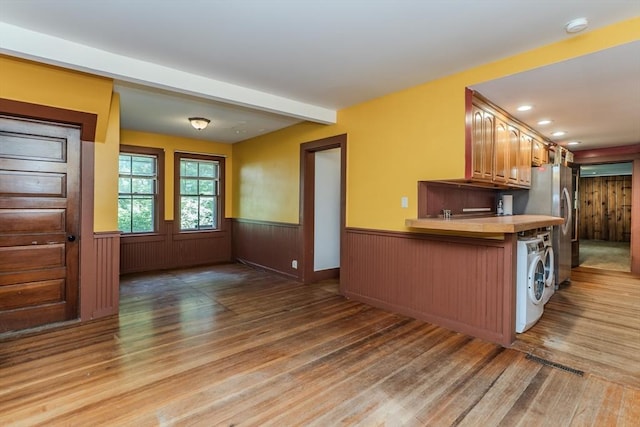 52 Maple St, Belchertown, MA 01007 - kitchen featuring wood finished floors, a wainscoted wall, washing machine and clothes dryer, freestanding refrigerator, and light countertops