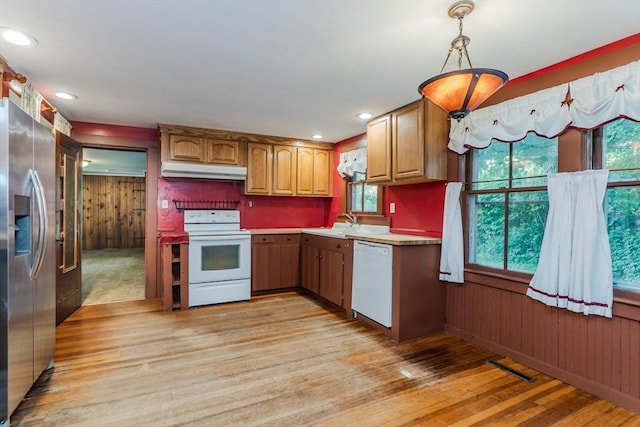 52 Maple St, Belchertown, MA 01007 - kitchen featuring white appliances, under cabinet range hood, light wood-type flooring, light countertops, and wood walls