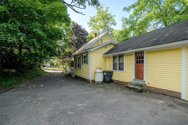 52 Maple St, Belchertown, MA 01007 - view of home's exterior featuring driveway, entry steps, a chimney, and a shingled roof