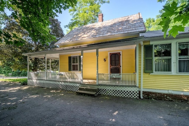 52 Maple St, Belchertown, MA 01007 - view of front of house featuring a porch and a chimney