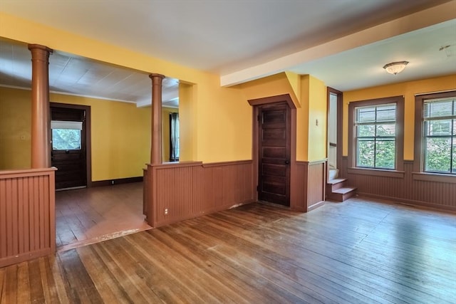 52 Maple St, Belchertown, MA 01007 - empty room featuring hardwood / wood-style floors, wainscoting, plenty of natural light, decorative columns, and wood walls