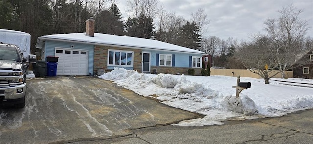 single story home with stone siding, aphalt driveway, a chimney, and an attached garage