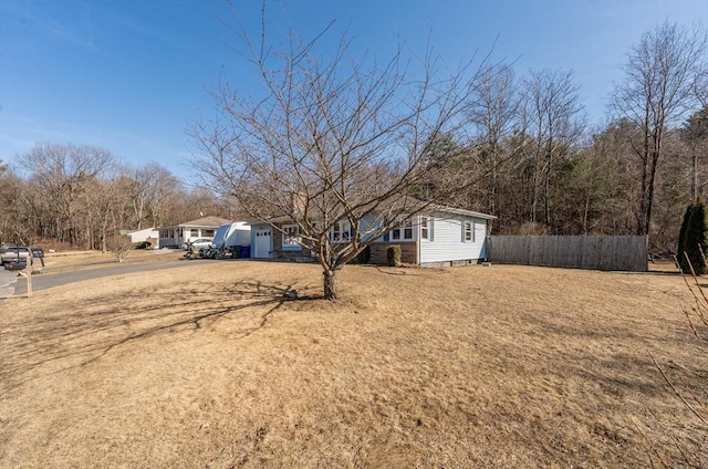 view of yard with driveway and fence