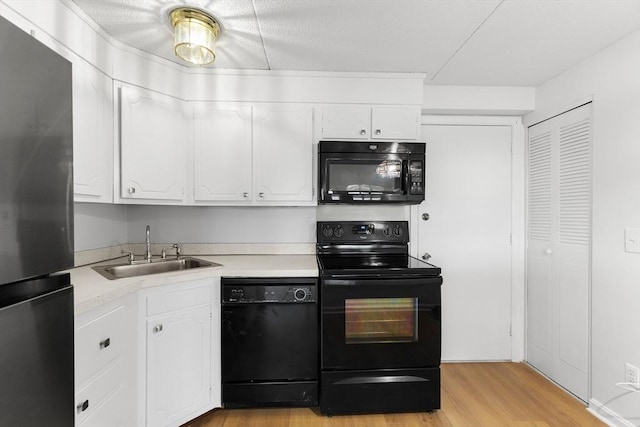 53 Melrose St Unit 7F, Melrose, MA 02176 - kitchen featuring black appliances, a sink, white cabinetry, light wood-style flooring, and light countertops