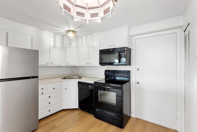 53 Melrose St Unit 7F, Melrose, MA 02176 - kitchen with black appliances, a sink, white cabinetry, light wood finished floors, and light countertops