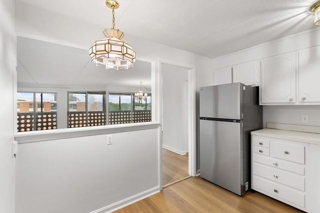 53 Melrose St Unit 7F, Melrose, MA 02176 - kitchen featuring freestanding refrigerator, a chandelier, white cabinetry, and plenty of natural light