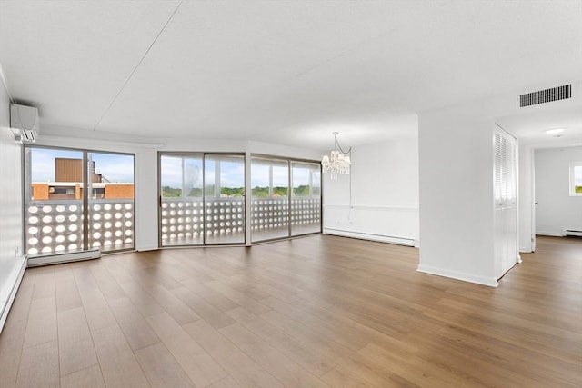 53 Melrose St Unit 7F, Melrose, MA 02176 - unfurnished living room featuring baseboard heating, an AC wall unit, a chandelier, and wood finished floors