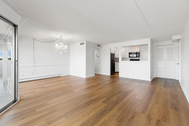 53 Melrose St Unit 7F, Melrose, MA 02176 - unfurnished living room featuring a baseboard heating unit, a chandelier, wood finished floors, and baseboards