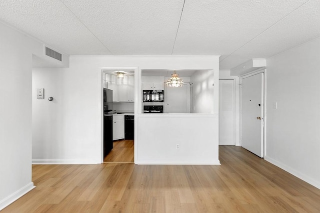 53 Melrose St Unit 7F, Melrose, MA 02176 - kitchen featuring light wood finished floors, a textured ceiling, baseboards, stove, and white cabinets