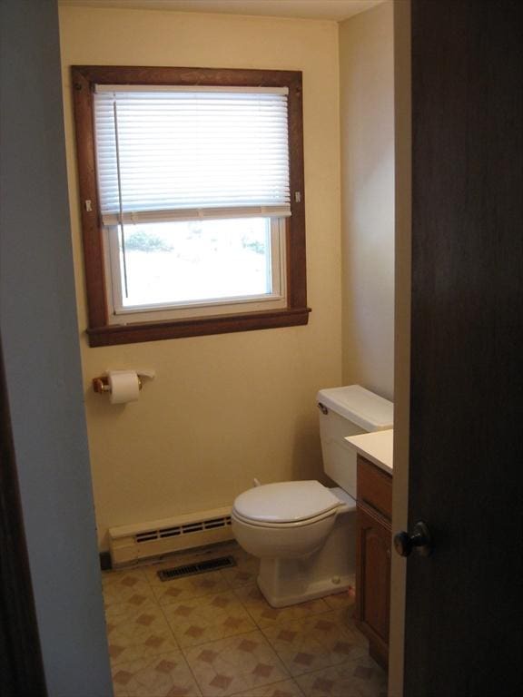 bathroom with a baseboard heating unit, vanity, and toilet