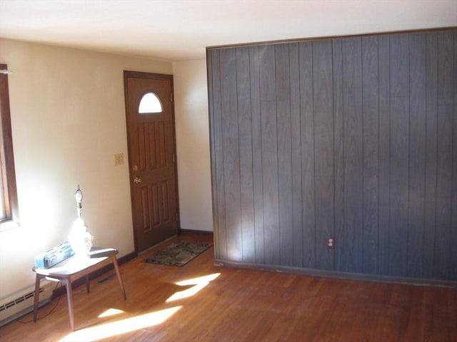 entryway with a baseboard radiator, baseboards, and wood finished floors