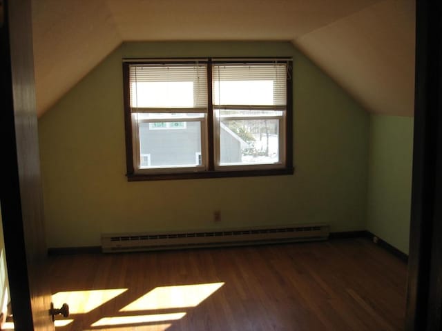 bonus room featuring baseboards, vaulted ceiling, baseboard heating, and wood finished floors